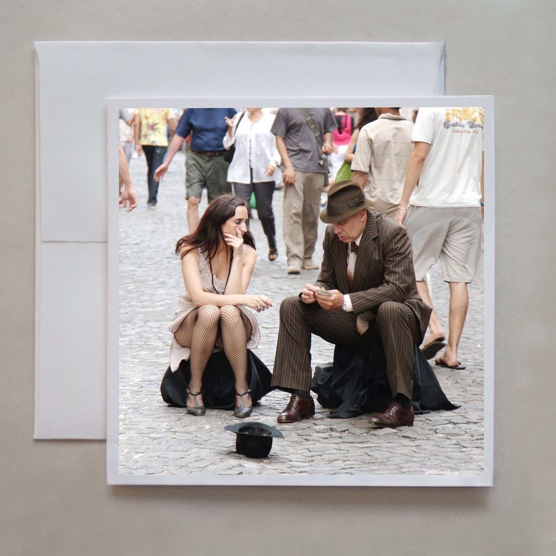 This photo greeting card shows two street tango dancers dividing their earnings outside a market in Argentina. © Caley Taylor Photography