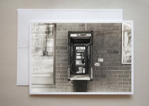 This is a gritting black and white photograph of a Toronto pay phone with graffiti tags all over by photographer Caley Taylor.