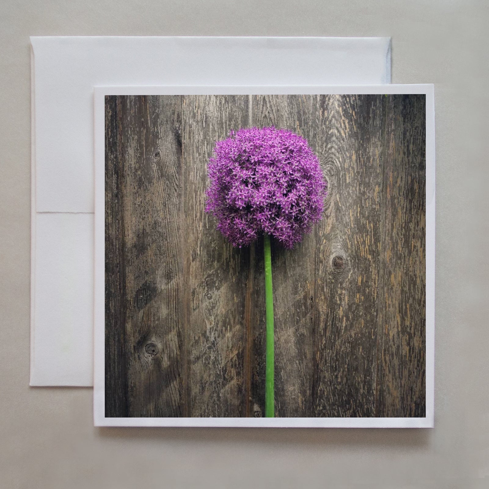 A beautiful purple flower notecard lying delicately on a wooden board by photographer Jennifer Echols.